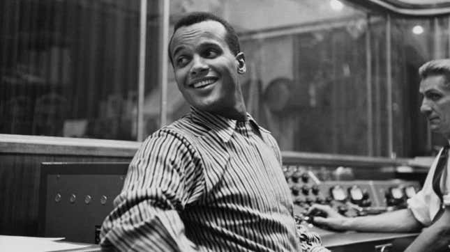 Harry Belafonte, wearing a striped shirt, in an recording studio, circa 1957.